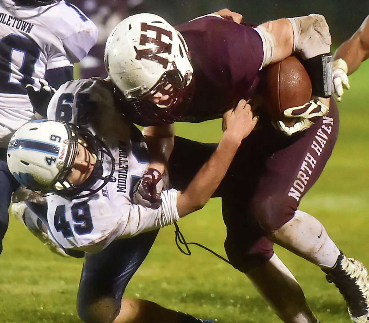 North Haven’s Conner Suraci is tackled by Middletown’s Michael Souza as the Indians defeat the Middletown Blue Dragons, 48-13, in the Class L state football quarterfinal game, Tuesday, December 1, 2015, at Vanacore Field at the North Haven Athletic Complex. (Catherine Avalone/New Haven Register)