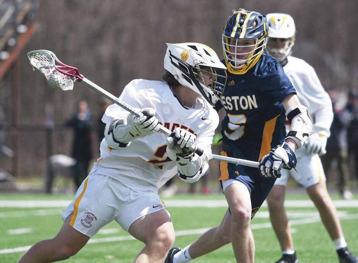 St. Joseph’s Sam Rosa (2) looks for a shot while Weston’s Henry Katz (5) defends during a boys lacrosse game in Trumbull on Saturday, April 9, 2022.