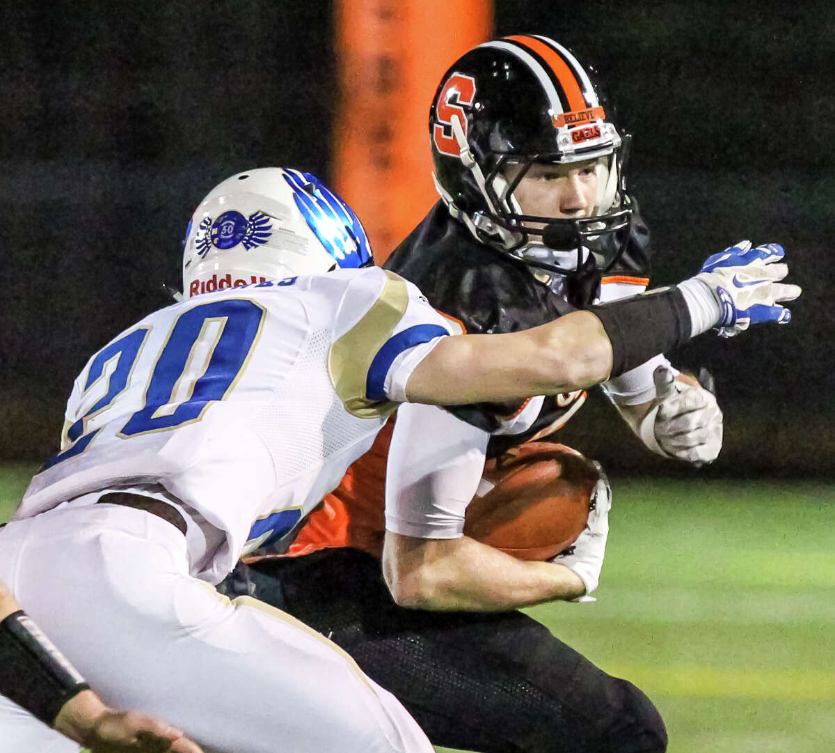 Shelton receiver Kevin Robinson slips out of the tackle by Newton’s Michael Doyle during Shelton’s 35-28 win over Newtown Monday in the Class LL semifinals