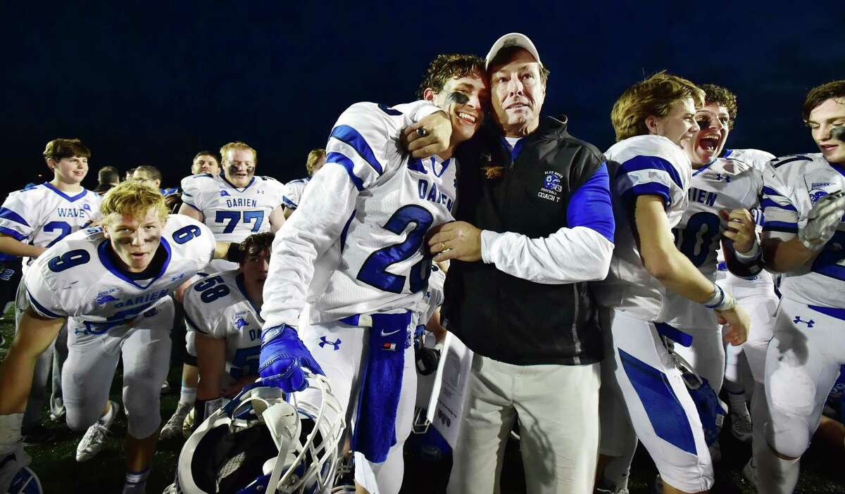 Darien head coach Rob Trifone embraces his son, Robby Trifone celebrating their victory over the Shelton Gaels, 39-7, for the Class LL state football championship, Saturday, December 12, 2015, at New Britain Stadium at Willowbrook Park in New Britain. (Catherine Avalone/New Haven Register)