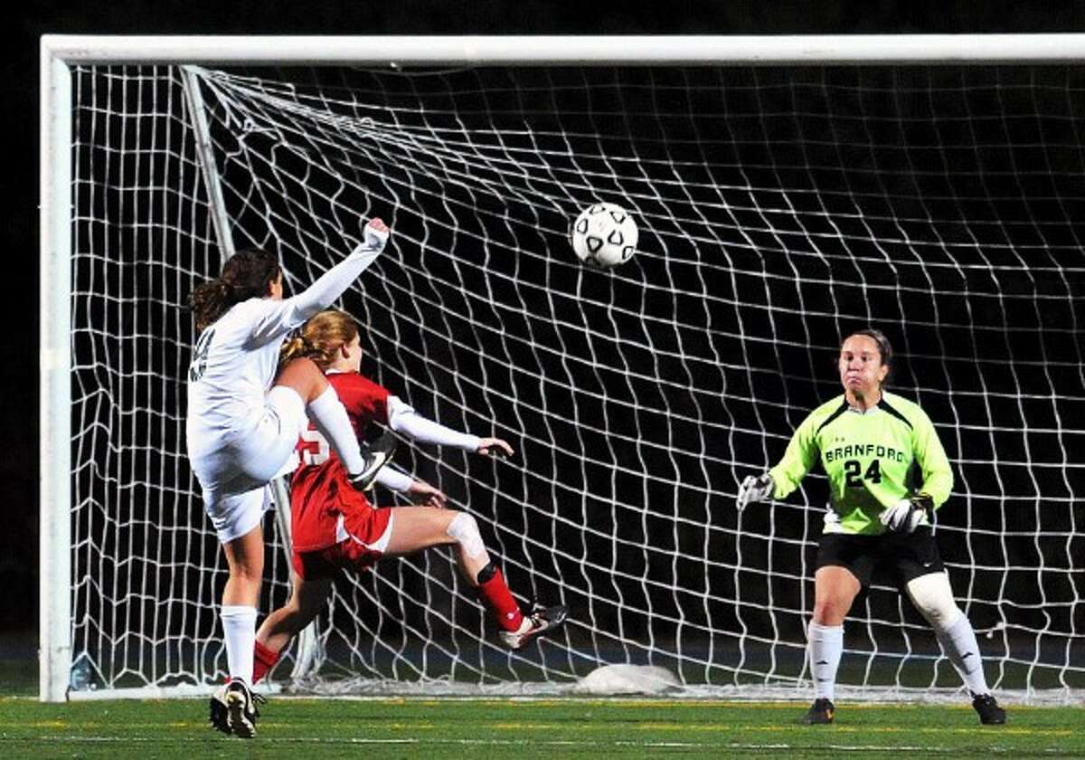 (Arnold Gold ?‘ New Haven Register) Allison Stephens (left) of Guilford scores past Branford goalie Rebecca Vitale (right) to go up 2-1 in the second half of the SCC Soccer Championship in East Haven on 10/30/2013.