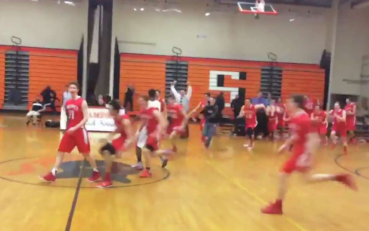 Greenwich’s Conor Harkins (left) delights in his winning 3-pointer at the buzzer in an upset win over Stamford in the Class LL boys basketball first round (Screencap via Greenwich Sentinel)