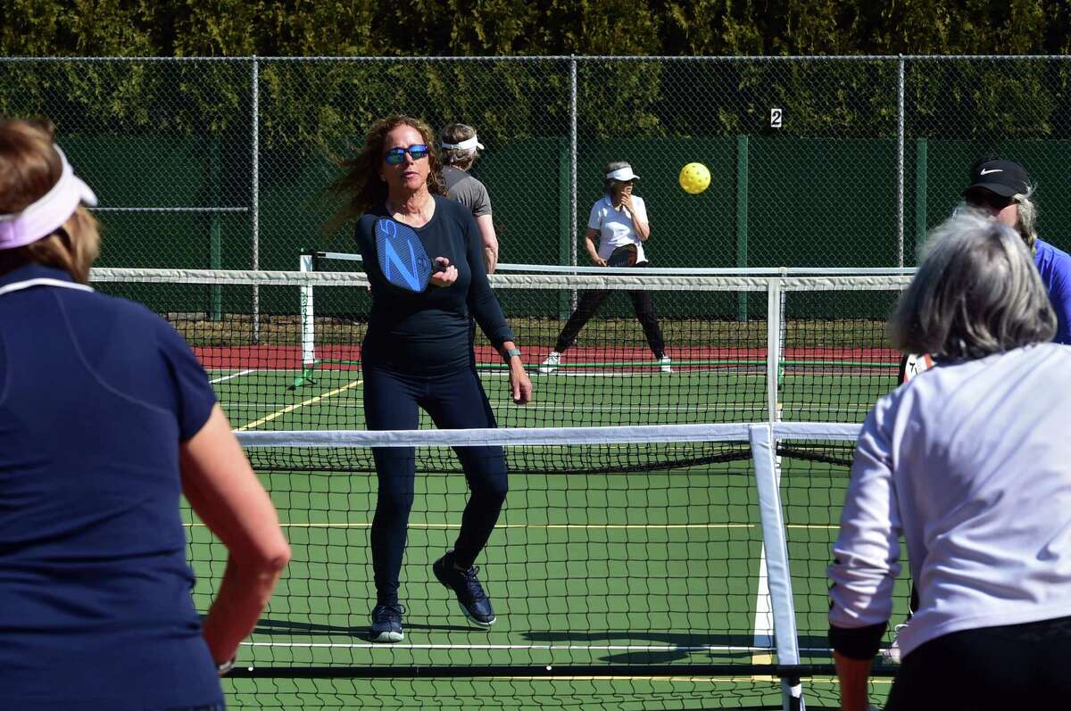Seniors play pickleball on the tennis courts at Loughlin Avenue Park in Greenwich, Conn., on Friday March 18, 2022. Pickleball, a sport gaining in popularity in the town, has plenty of seniors seeking to support and protect proposed funding for it in the upcoming town budget.
