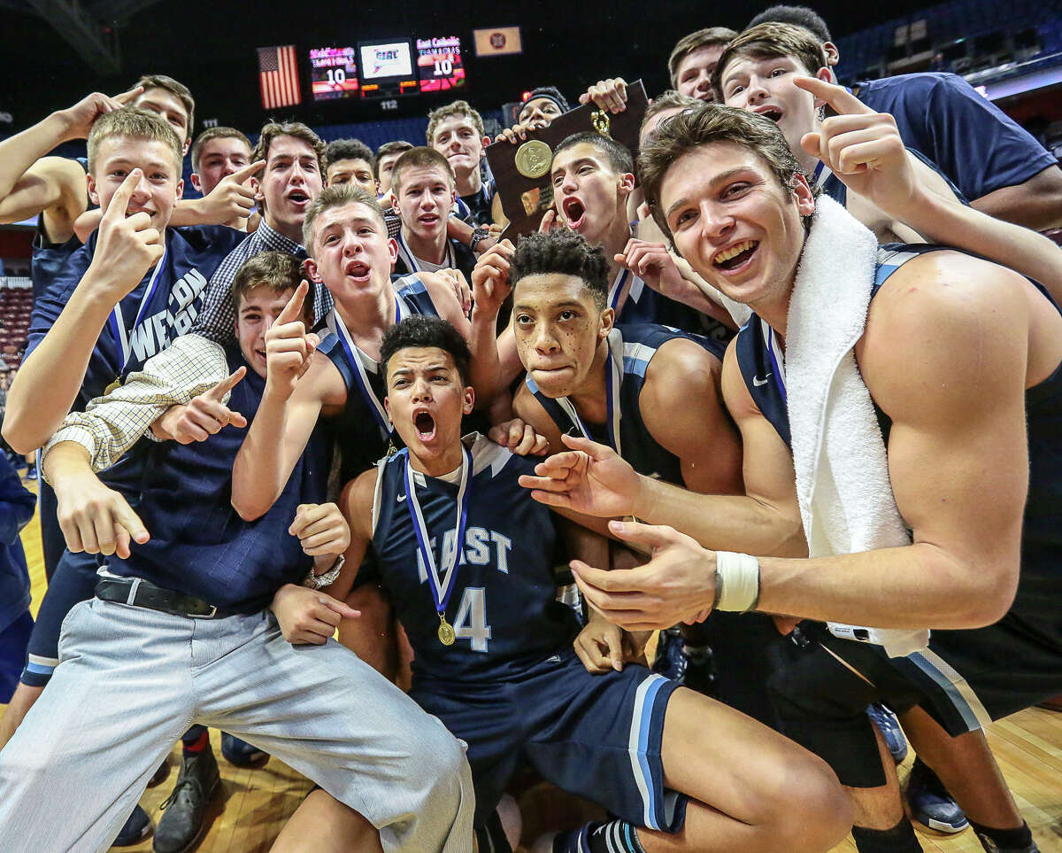 East Catholic celebrates its CIAC Class L state championship after beating Middletown 62-51 Saturday night.-John Vanacore/Register