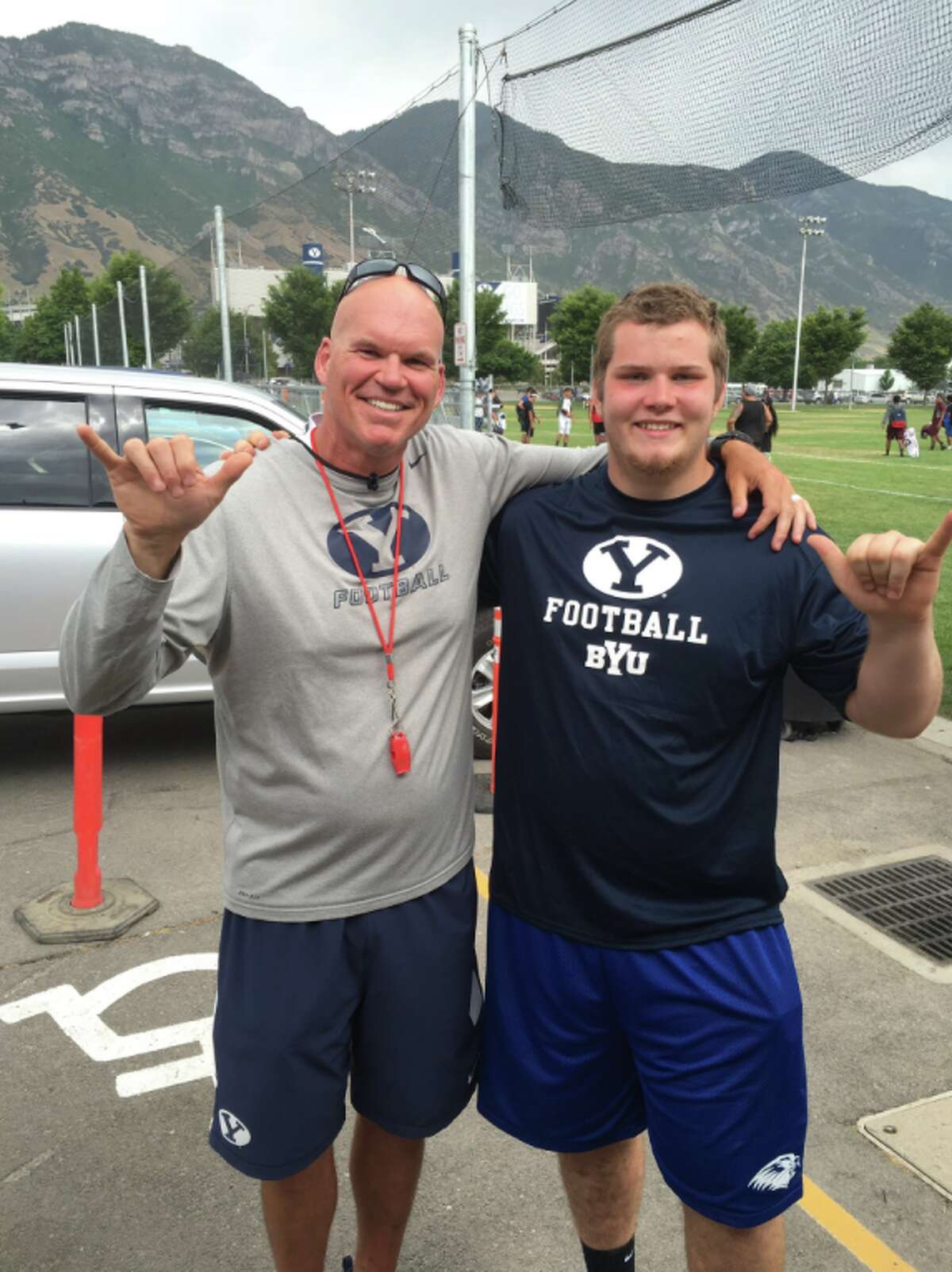 Newtown OL Seth Willis (right) with BYU offensive line coach Mike Empey. Willis gave his verbal commitment to play at the school next year. (Photo via Seth Willis via Twitter)
