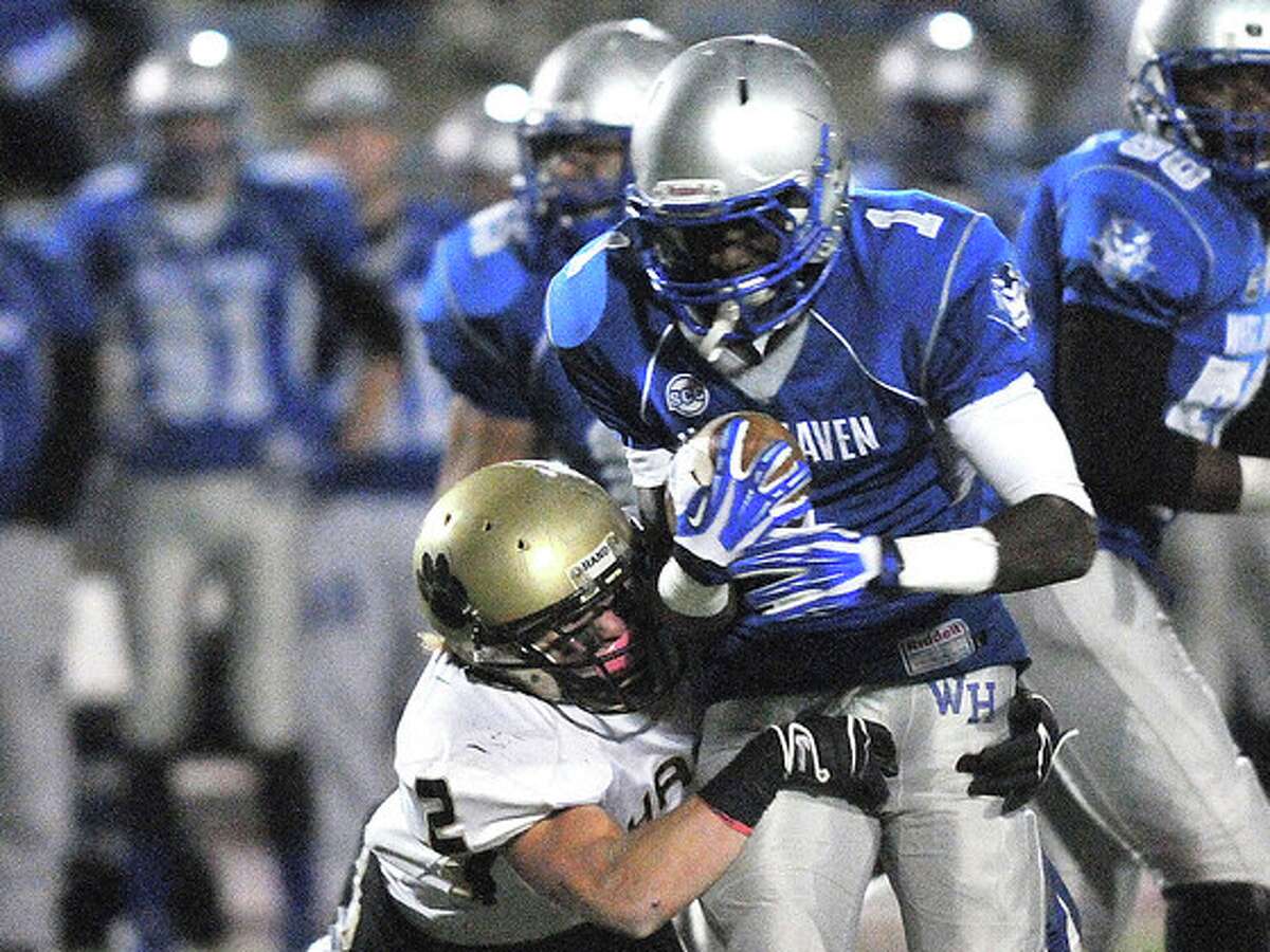 (Peter Casolino — New Haven Register) West Haven’s Ervin Philips drives for extra yards as Hand’s Tommy Wilson makes the tackle during the second quarter.