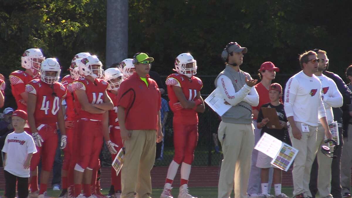Greenwich Coach John Marinell (right) during the team’s homecoming victory over Trumbull a day after it was revealed the program’s freshman team had used inappropriate play calls in a game.
