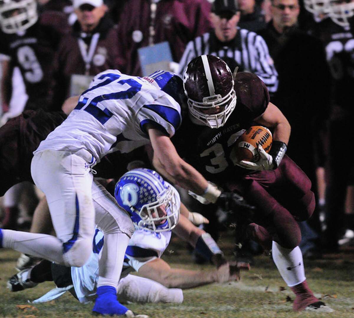 Darien’s Andrew Nault tries to take down North Haven’s Ethan Suraci Friday at Vanacore Field. The Blue Wave defeated North Haven 36-27. (Photo Arnold Gold)