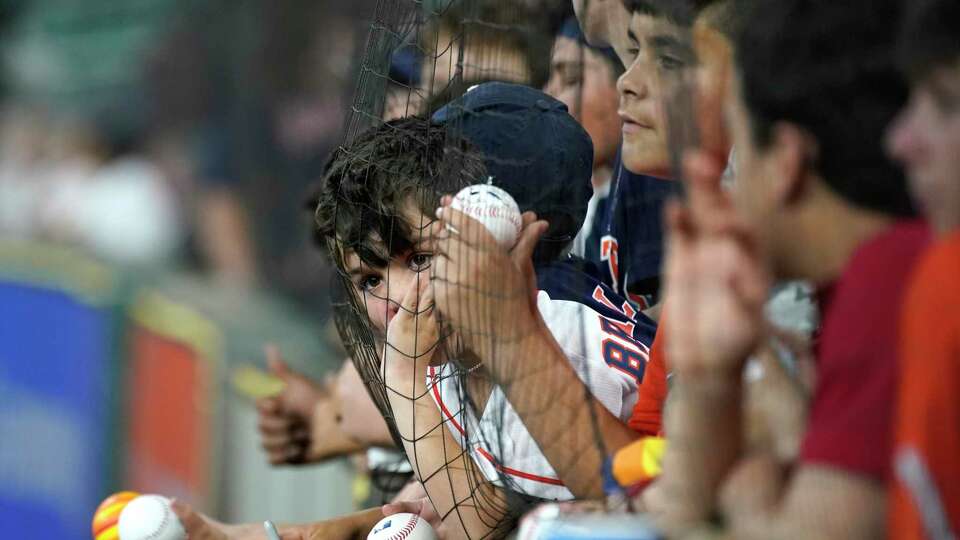 Kids wait for autographs against the fence before the start the first inning of an MLB baseball game at Minute Maid Park on Wednesday, April 20, 2022 in Houston.