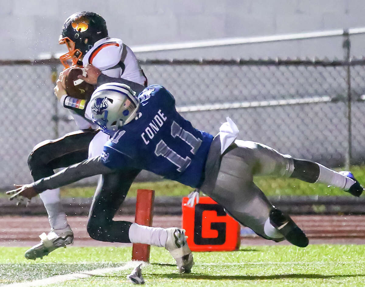 Ridgefield’s Aidan Spearman catches a a pass for a first half touchdown against West Haven’s Jose Conde to lead Ridgefield to their CIAC Class LL Quarterfinal win Tuesday evening.-John Vanacore/ New Haven Register