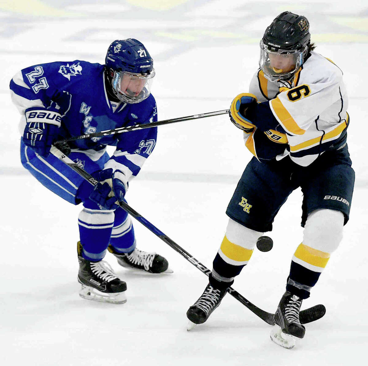 Collin Braziel of West Haven H.S., left, and Joe Lorello of East Haven fight over the puck during first period hockey action Monday afternoon, January 31, 2017 at DiLungo Rink in East Haven. (Peter Hvizdak – New Haven Register)