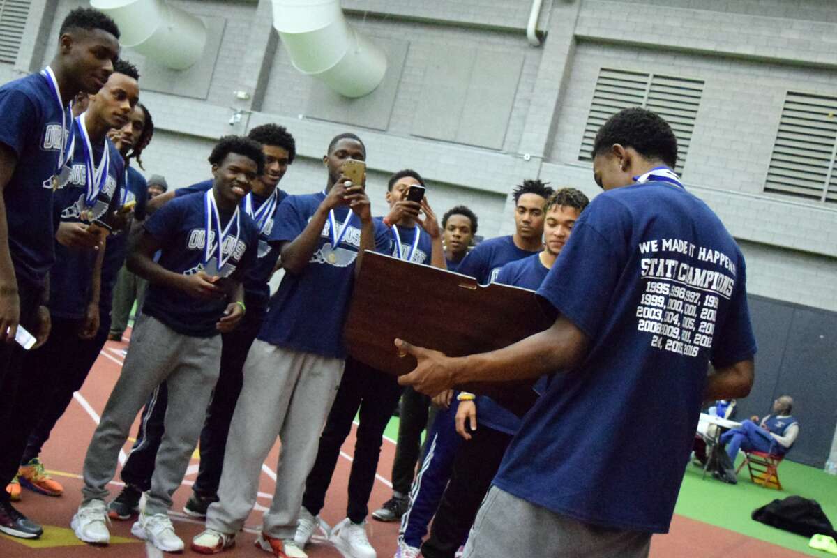 The Hillhouse boys indoor track team each pose for a picture with the Class M State Championship plaque. The Academics have won three straight state titles. (Derek Turner/GameTimeCT)