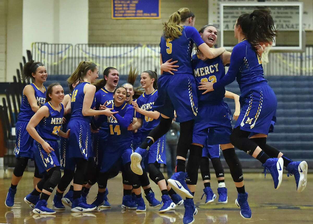 Mercy junior guard Isabella Santoro (5) and senior guard Tia Giansiracusa (13) join Mercy junior forward Samantha Chapps (23) in a victory celebration after the Tigers defeat Daniel Hand, 49-39, in the SCC championship game, Wednesday, February 22, 2017, at the Edna L. Fraser Gymnasium at East Haven High School. (Catherine Avalone/New Haven Register)