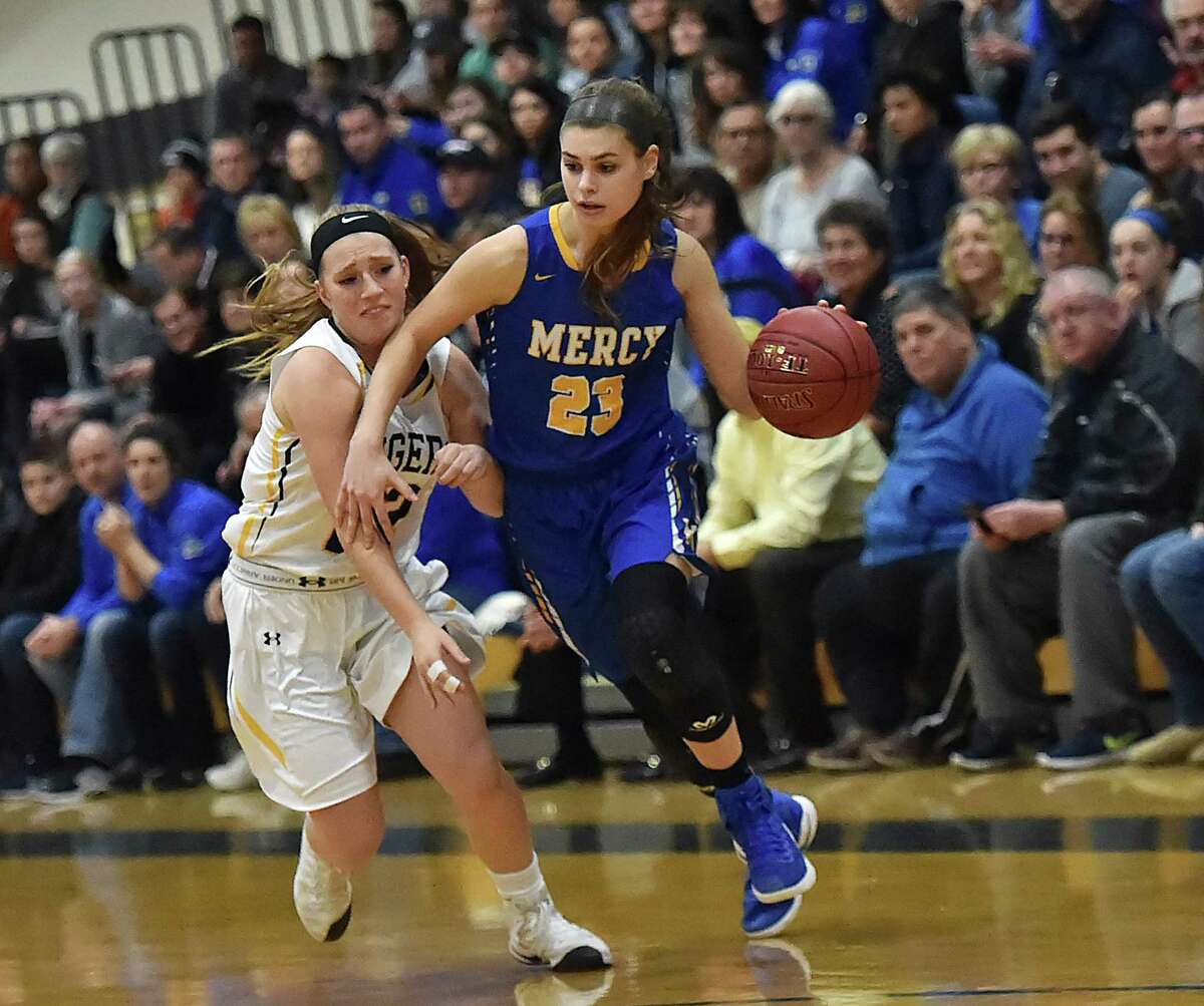 Mercy junior forward Samantha Chapps drives past Hand junior guard Gabby Egidio as the MercyTigers defeat the Daniel Hand Tigers, 49-39, in the SCC championship game, Wednesday, February 22, 2017, at the Edna L. Fraser Gymnasium at East Haven High School. (Catherine Avalone/New Haven Register)