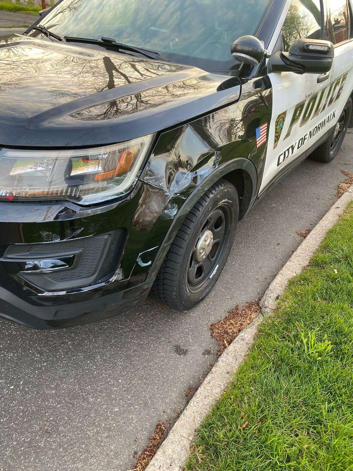 Authorities said officers were investigating a crash near the Norwalk Green in Norwalk, Conn., on Wednesday, April 20, 2022, when two cruisers were struck by another vehicle.