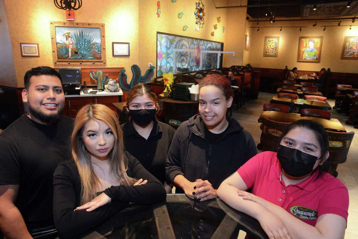 Co-owner Gabriela Velazquez, second from left, poses with members of the staff at Guacamole's Mexican Cuisine, in Westfield Trumbull Mall in Trumbull, Conn. April 20, 2022.
