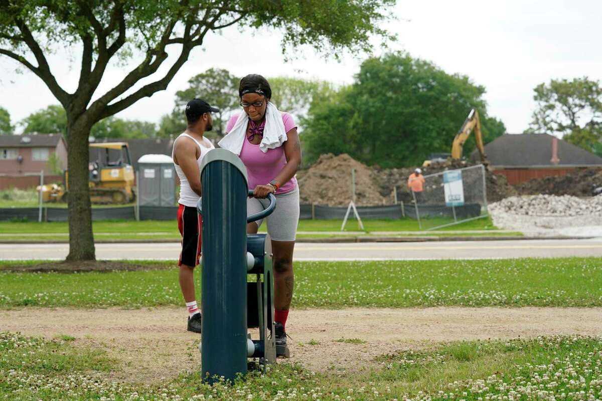 Hershel Cartwright and Latoya Cartwright stop at a workout station along the walking path at Hunters Glen Park where a gas station is under construction across the street from the park Friday, April 15, 2022, in Missouri City. A group of area residents have spoken out against the gas station that's being built in their neighborhood and across the street from Hunters Glen Park.