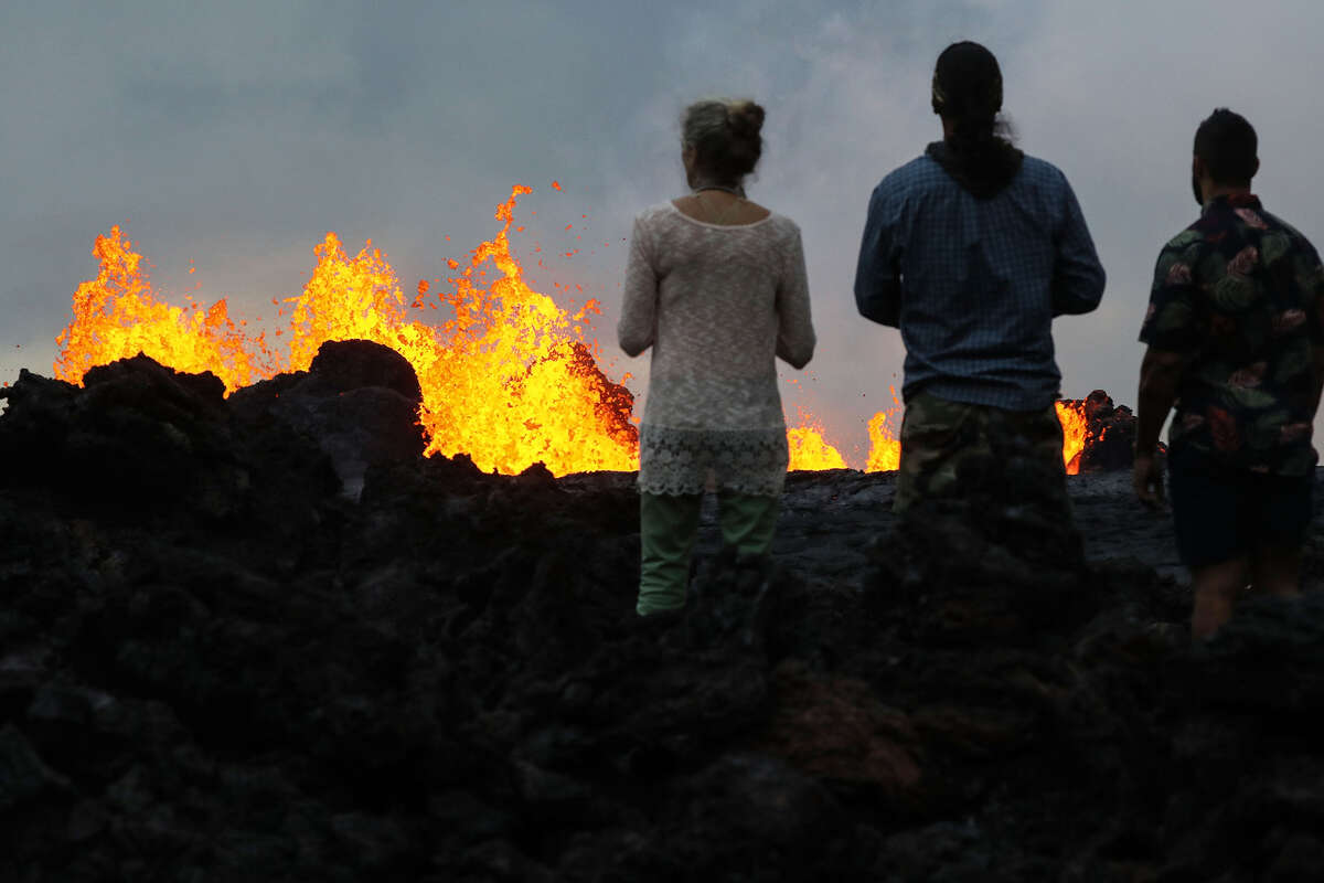 Onlookers watch as lava from a Kilauea Volcano fissure erupts in Leilani Estates, on Hawaii's Big Island, on May 26, 2018, in Pahoa, Hawaii. 