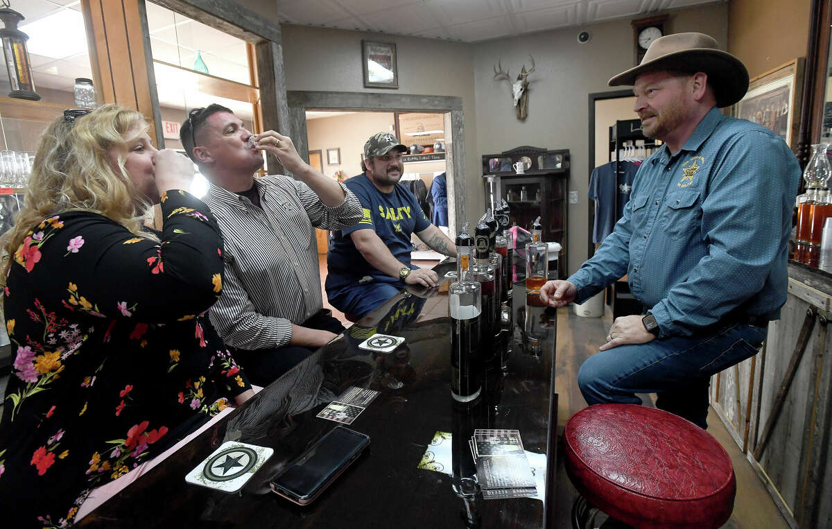 Sean Clifford watches as long-time friends Pam and Kevin Brummett of College Station sample his wares at a tasting during the grand opening of Clifford Distilling in downtown Port Arthur Thursday. The opening celebration continues through the weekend with tours and tastings of the whiskeys and rums being produced on site by owner Sean Clifford and family. Photo made Thursday April 21, 2022. Kim Brent/The Enterprise
