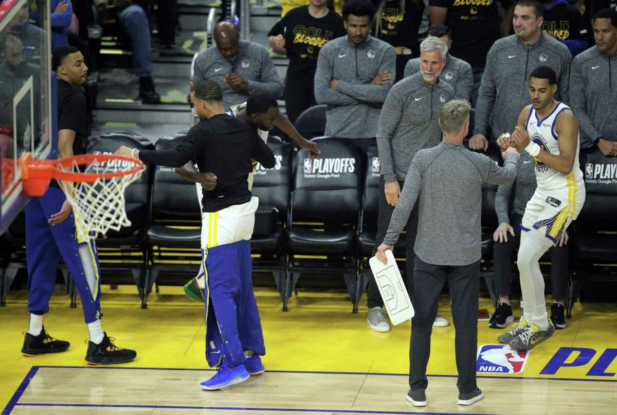 Stephen Curry (30) gets a hug from Draymond Green (23) as Jordan Poole (3) gets a fist bump from Steve Kerr before the Golden State Warriors played the Denver Nuggets in game 2 of the NBA Playoffs first round at Chase Center in San Francisco, Calif., on Monday, April 18, 2022.