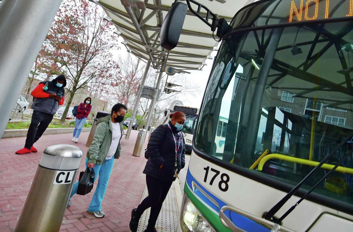 People wear masks as they get onto a Norwalk Transit District bus at the Norwalk Mall/WHEELS Hub in downtown Norwalk, Conn., on Thursday April 21, 2021. Masks are still required by the city to be worn on all city buses.