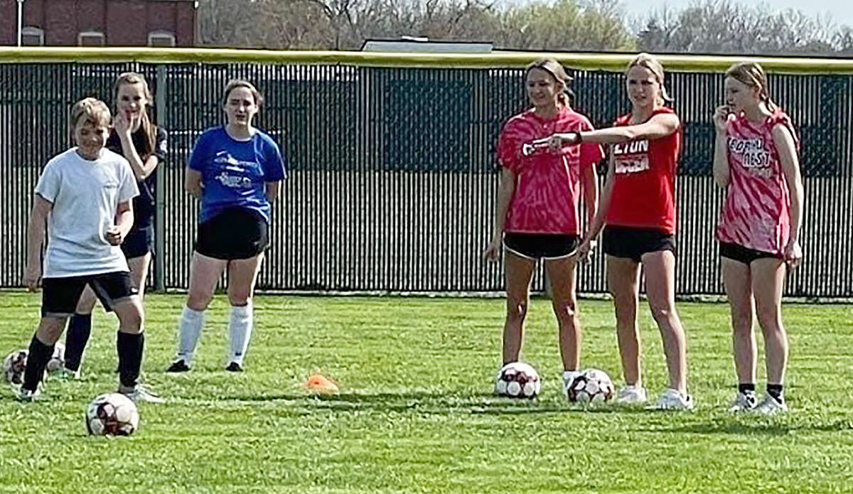 Alton High varsity soccer players give instructions to Alton Middle School player at a practice Thursday at Alton Middle School. The AHS varsity players organized and ran the practice.