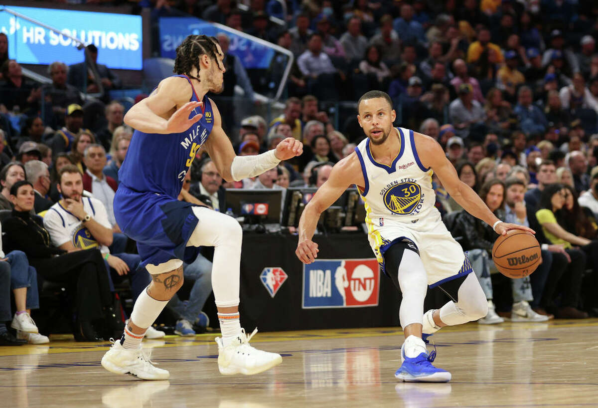 Golden State Warriors guard Stephen Curry, right, is guarded by Denver Nuggets forward Aaron Gordon in the second half at Chase Center on April 18, 2022, in San Francisco, Calif.