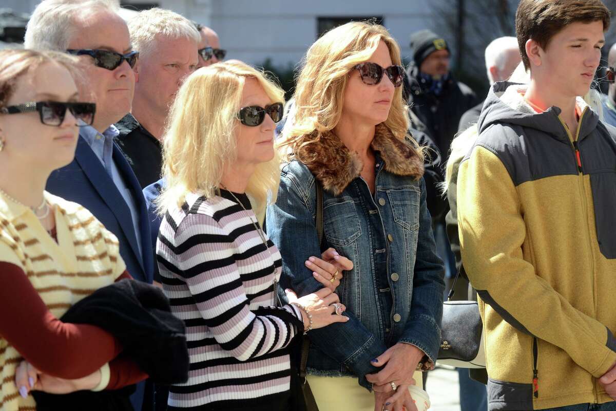 Sisters Paula Gill and Patti Charette attend a L’Ambiance Plaza memorial ceremony in Bridgeport, Conn. April 22, 2022. Their father, Richard McGill, was one of 28 workers killed in the 1987 construction accident. Saturday marks the 35th anniversary of the accident.