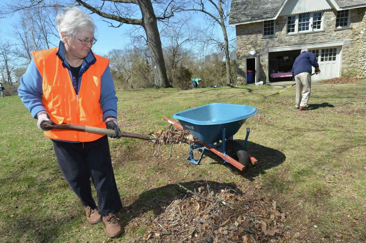 Norwalk Land Trust Stewardship Chair Sarah Graber picks up a pile of leaves and nuts from the hickory trees during Earth Day Cleanup on Sunday April 22, 2018 at Farm Creek Preserve in Norwalk Conn. The Norwalk Land Trust provided Tools, gloves and bags for the volunteers who helped to prepare the preserve for the Trust's spring Outdoor Classrooms that have given more than 900 Norwalk fourth-graders an outdoor environmental experience.