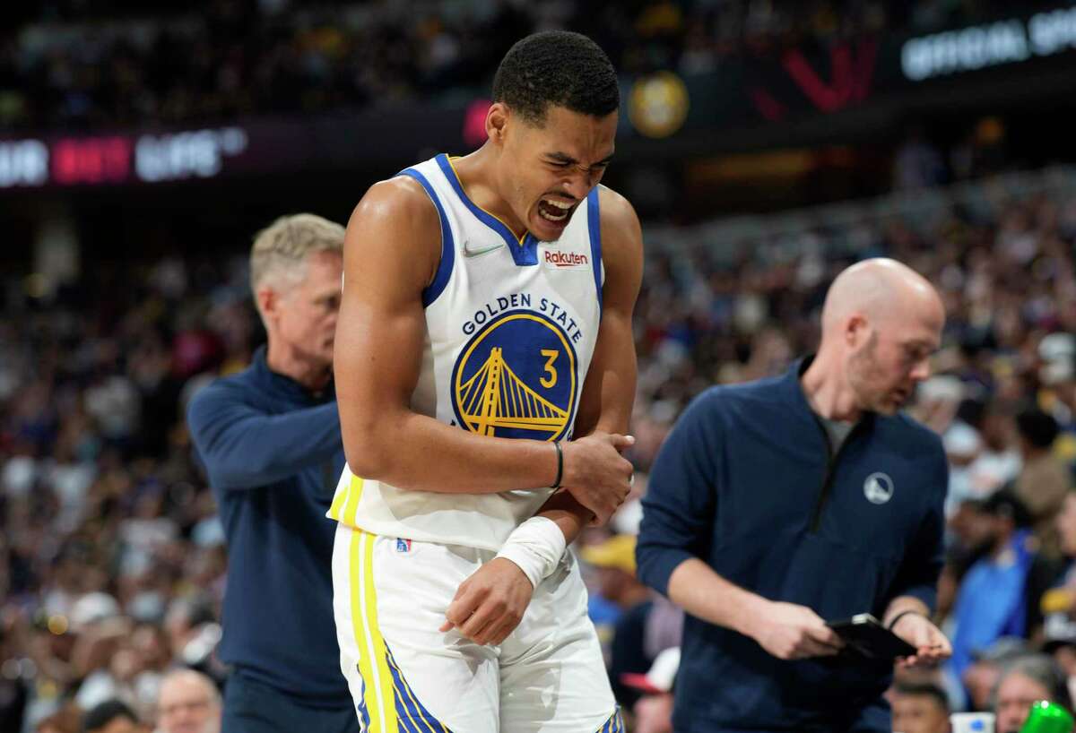 Golden State Warriors guard Jordan Poole heads to the bench after being injured during the second half of Game 3 of the team's NBA basketball first-round Western Conference playoff series against the Denver Nuggets on Thursday, April 21, 2022, in Denver. Poole later returned to the game. (AP Photo/David Zalubowski)