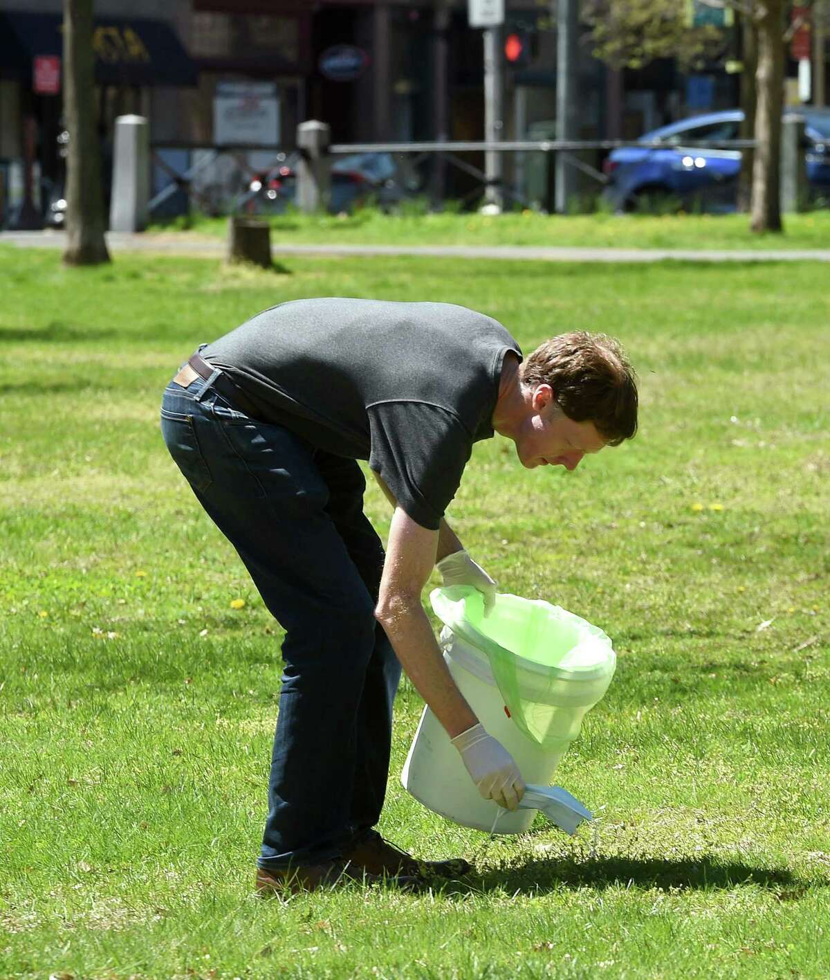 New Haven Mayor Justin Elicker picks up trash during an Earth Day Clean the Green event on the New Haven Green Friday.