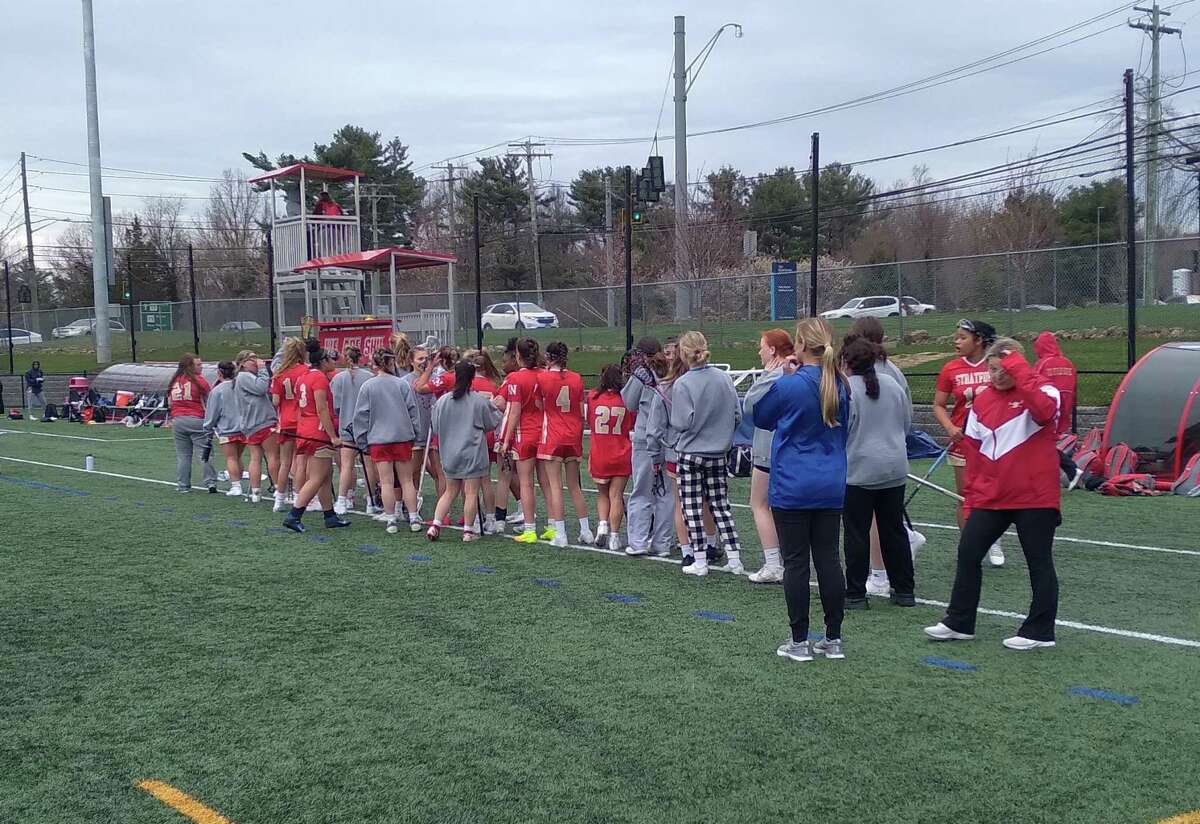 The Stratford/Bunnell co-op girls lacrosse team lines up to shake hands with Notre Dame-Fairfield after their game on April 21, 2022, at Park Avenue Field in Fairfield, Conn.