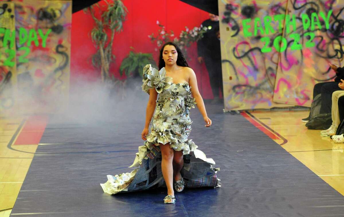 As part of J.M. Wright Technical High School's Earth Day Celebration, student Karla Segovia models a newspaper dress during its "trashy" fashion show in the gymnasium in Stamford, Conn., on Friday April 22, 2022. Students have been tasked with creating wearable fashion using any type of recycled material, including plastic bags and bottles, packing materials, fabric scraps and swatches, coffee filters and cardboard.