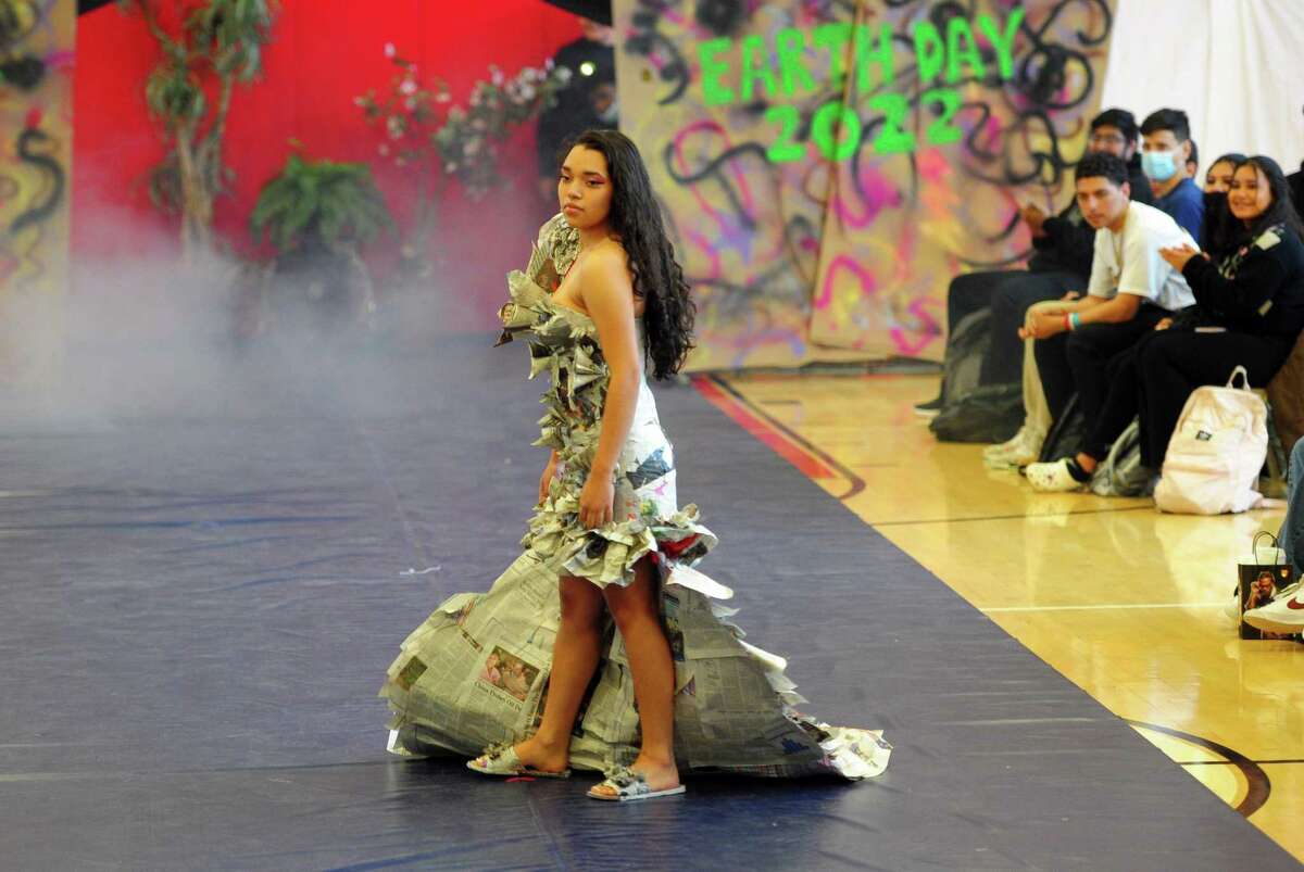 As part of J.M. Wright Technical High School's Earth Day Celebration, student Karla Segovia models a newspaper dress during its "trashy" fashion show in the gymnasium in Stamford, Conn., on Friday April 22, 2022. Students have been tasked with creating wearable fashion using any type of recycled material, including plastic bags and bottles, packing materials, fabric scraps and swatches, coffee filters and cardboard.