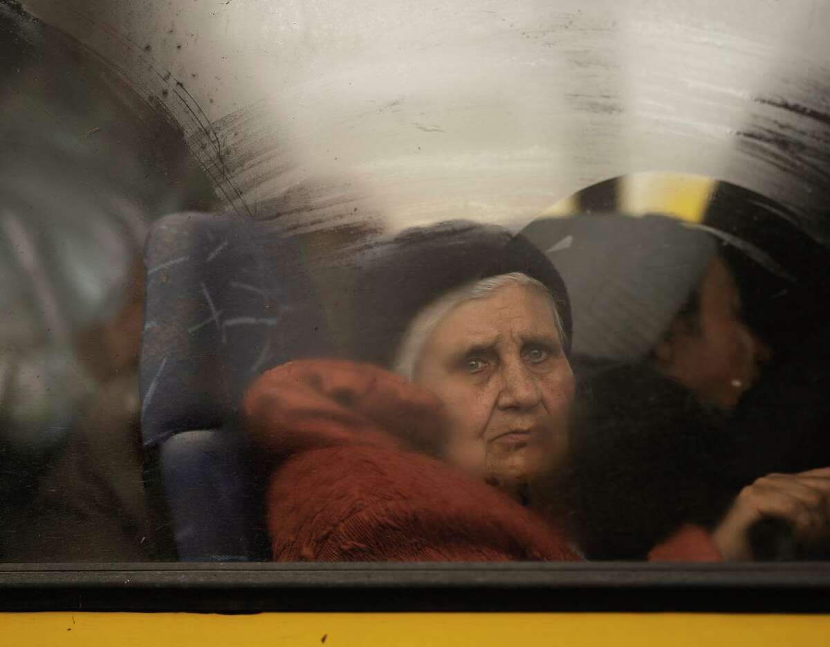 A woman fleeing the fighting in Mariupol, Ukraine, arrives Thursday on a bus at a refugee center about 150 miles away in the city of Zaporizhzhia.