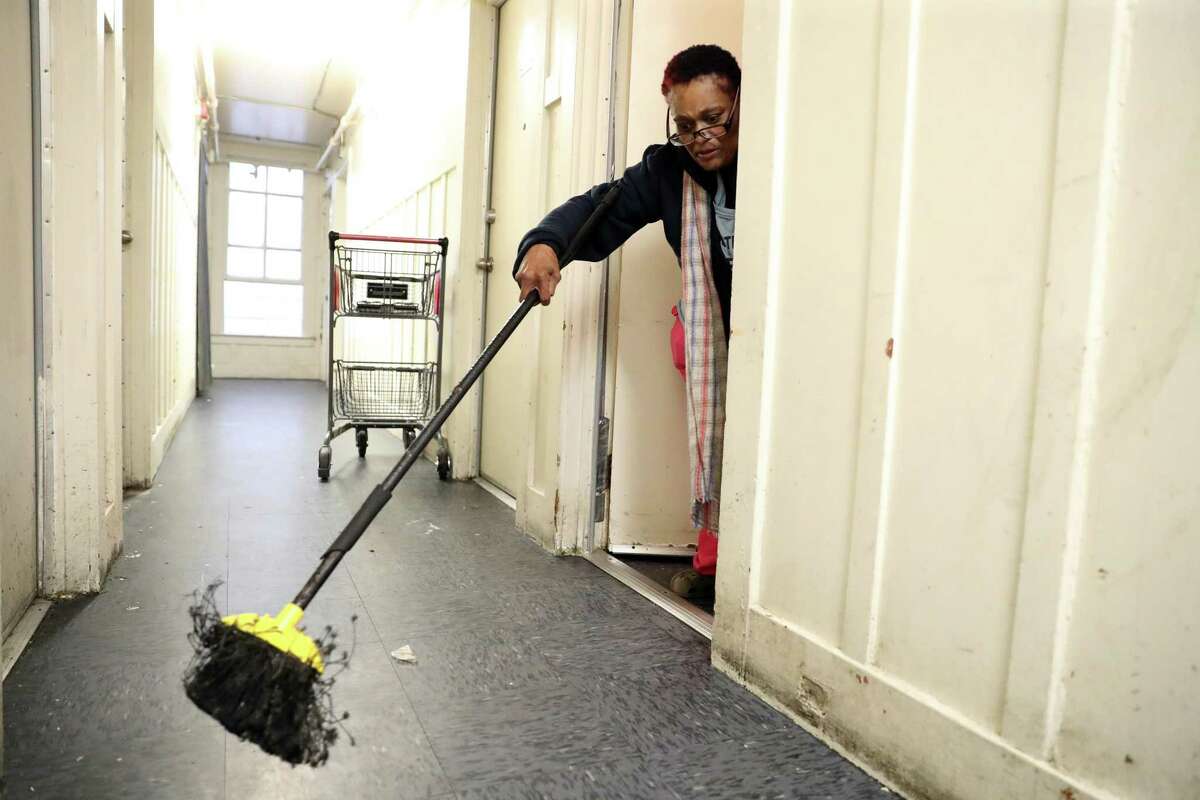 Ericka Marie Stuetson sweeps bugs out of her room at the Mission Hotel in San Francisco.