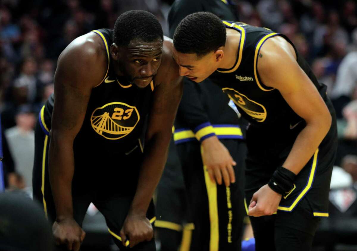 Jordan Poole (3) checks on Draymond Green (23) after he was fouled and fell to court in the second half as the Golden State Warriors played the Phoenix Suns at Chase Center in San Francisco, Calif., on Wednesday, March 30, 2022.