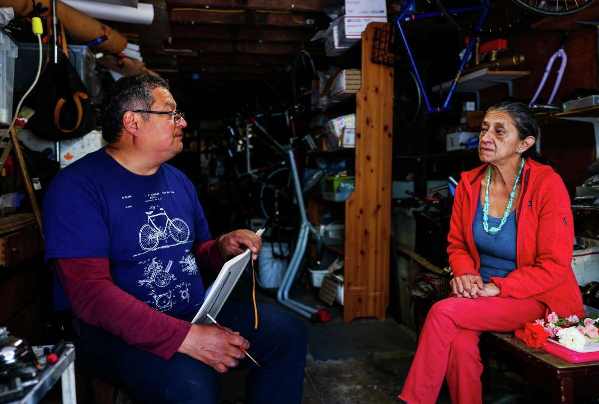 Andrés Rojo (left) talks with friend and fellow artist Denhi Donis at the garage studio he must leave in less than 40 days after losing a commercial eviction lawsuit over whether the space posed a nuisance.