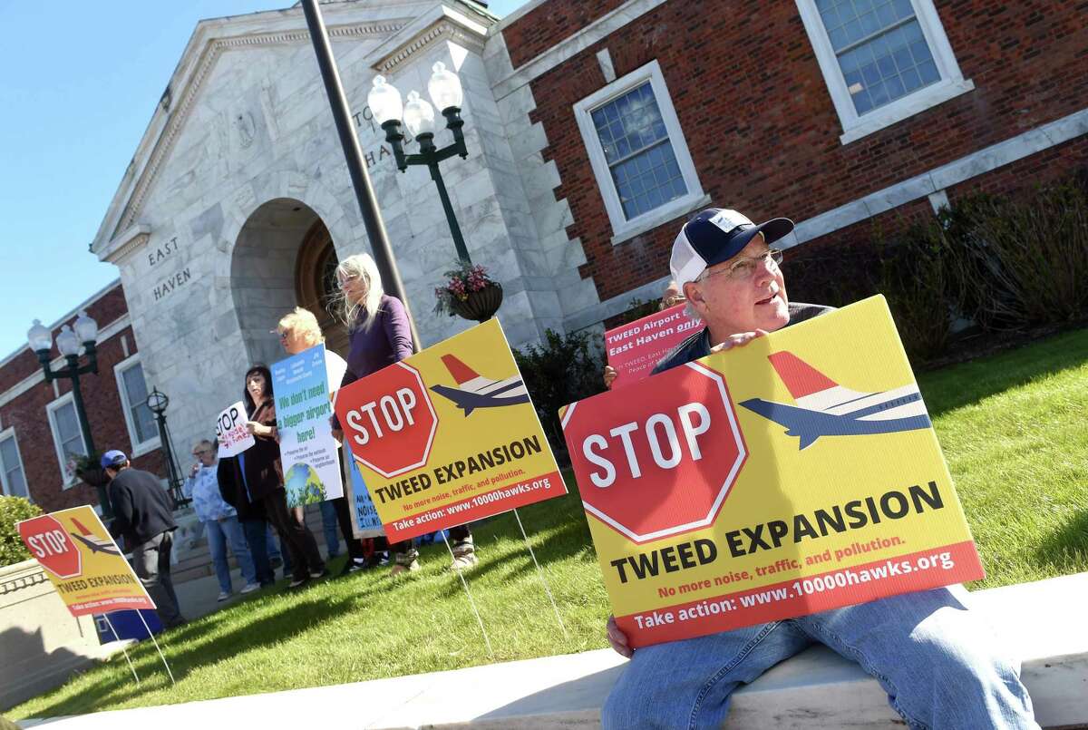 Ed Fitzgerald (right) of New Haven joins others to protest the expansion of Tweed New Haven Regional Airport in front of East Haven Town Hall on April 22, 2022. Fitzgerald lives across the street from the airport.