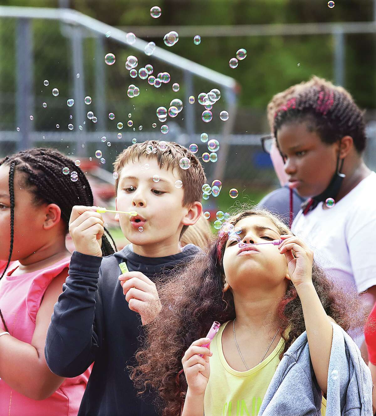 Students blew bubbles to celebrate after the ribbon was cut to open their new outdoor classroom Friday at East Elementary School in Alton.