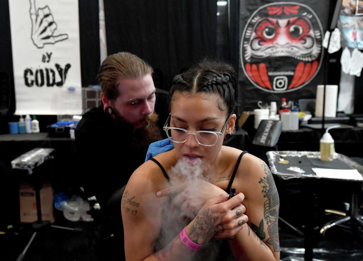 Emily Johnson gets work done by Josh Dunning on the opening day of this Ink Masters Tattoo Convention that runs through Sunday at the MCM Elegante Hotel. Photo made Friday April 22, 2022. Kim Brent/The Enterprise