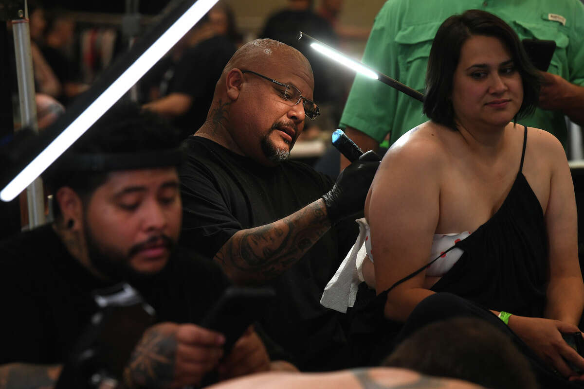 Rick Escovar gets to work on a tattoo alongside fellow artists on the opening day of this Ink Masters Tattoo Convention that runs through Sunday at the MCM Elegante Hotel. Photo made Friday April 22, 2022. Kim Brent/The Enterprise