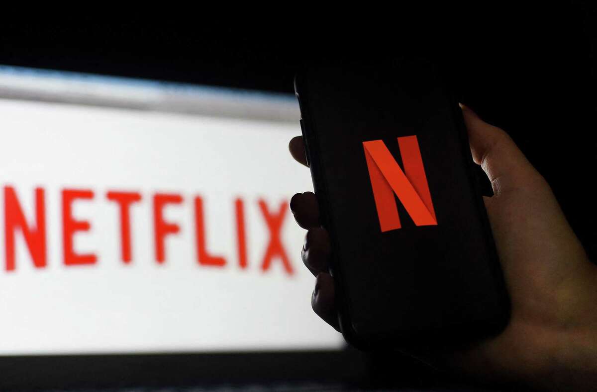 (FILES) In this photo illustration a computer and a mobile phone screen display the Netflix logo on March 31, 2020 in Arlington, Virginia. - Netflix on July 15, 2021 confirmed that it recruited a video game veteran from Facebook to lead a gaming team at the television star Mike Verdu was hired to take charge of video game development at the Silicon Valley company, which has openly called hits such as "Fortnite" competition for people's online entertainment time. (Photo by Olivier DOULIERY / AFP) (Photo by OLIVIER DOULIERY/AFP via Getty Images)