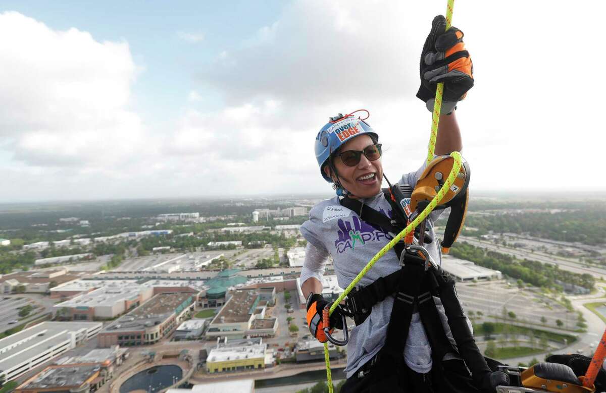 Rey Black rappels off the top of The Woodlands Towers during the annual Over The Edge fundraiser for Camp for All, Saturday, April 23, 2022, in The Woodlands. Charitable daredevils rappelled down the 31-story building to raise money the organization, which provides 10,000 campers with special needs at their 206-acre, barrier-free facility in Burton, Texas.
