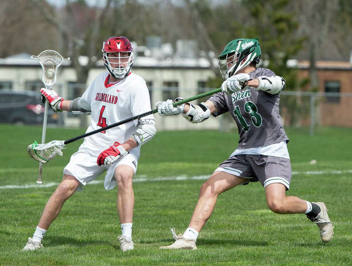 Guilderland Mitchell MacKissock dodges a poke from Shen defenseman Greg Sweet during a game at Guilderland High School on Saturday, Apr. 23, 2022 in Albany, N.Y. (Jenn March, Special to the Times Union)