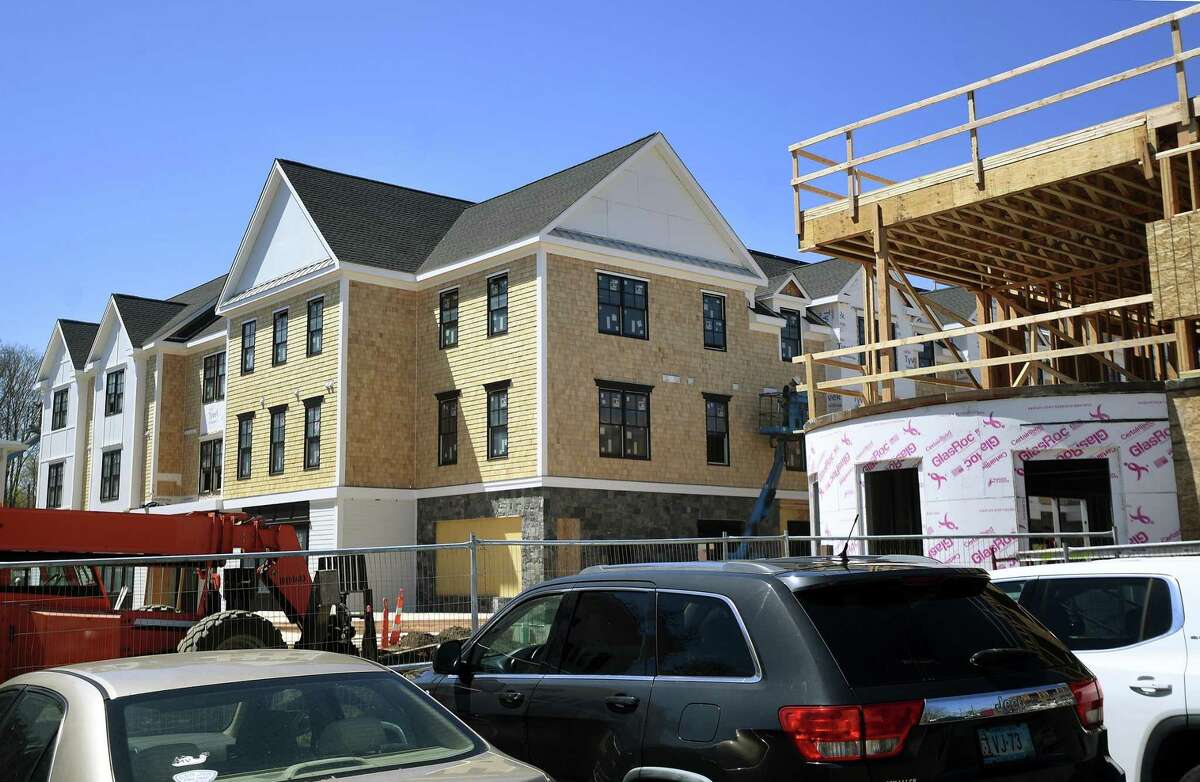 The massive new Metro Star Apartments development looms over Broad Street and the Green in downtown Milford, Conn., on Friday, April 22, 2022.