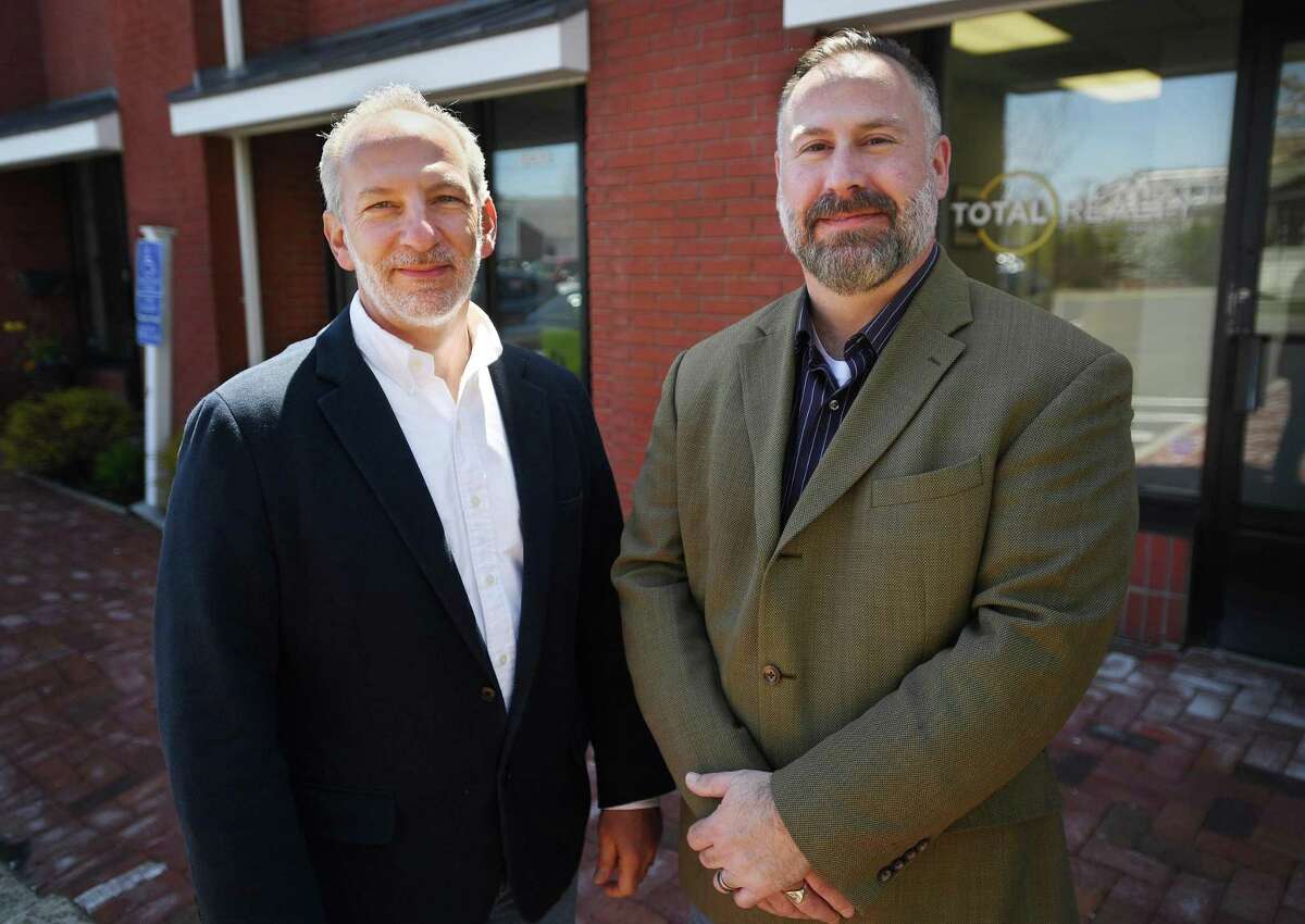 Total Realty partners Al Melotto, left, and Kevin Weisman outside their commercial/residential real estate business on Broad Street in Milford, Conn., on Friday, April 22, 2022.