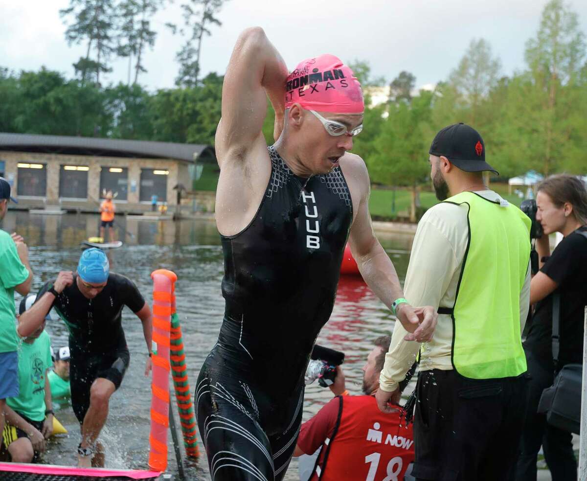 A triathlete heads to the bike transition after competing in the swimming portion of the Ironman Triathlon, Saturday, April 23, 2022, in The Woodlands.