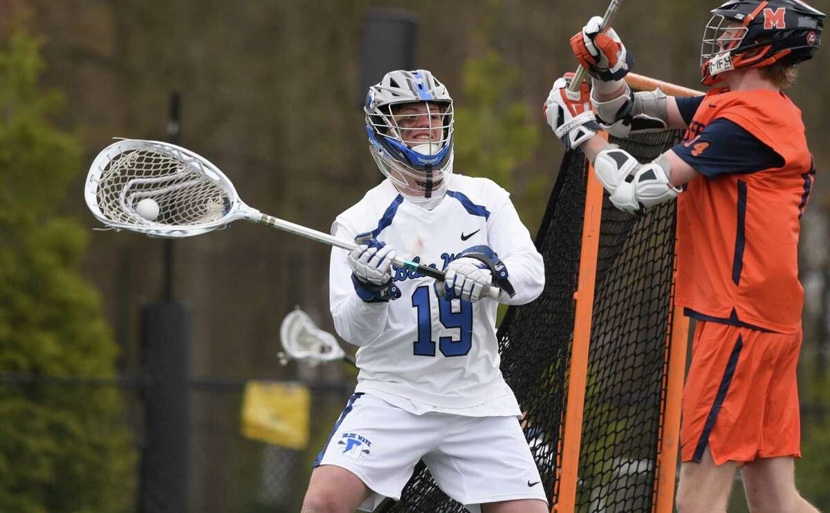Darien goalie Cam Weibel looks to clear the ball after making a save against Manhasset during a boys lacrosse game in Darien on April 23.