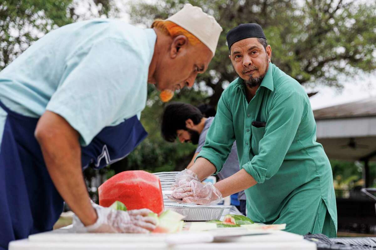 Kassim Ahmed Mudassar, right, and another volunteer cut a watermelon on Thursday to prepare for the Ramadan service at the Muslim Children Education and Civic Center and Almadinah Masjid in San Antonio.  All watermelon rinds are put in the MCECC compost bin.